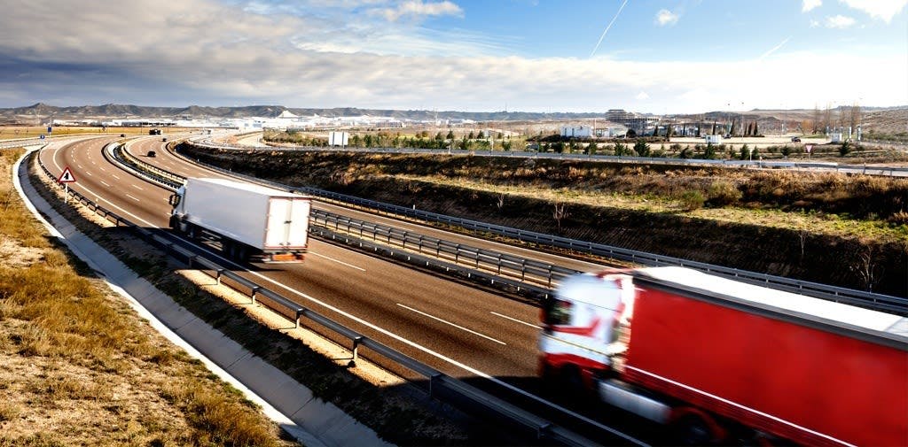 Large freight trucks driving on a freeway