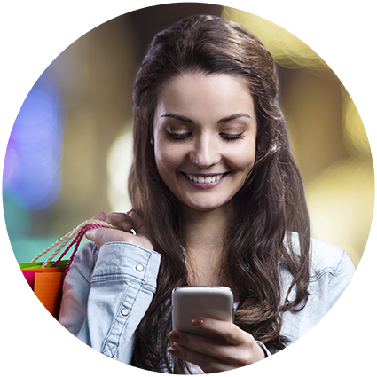 White women in denim shirt smiling and looking at phone