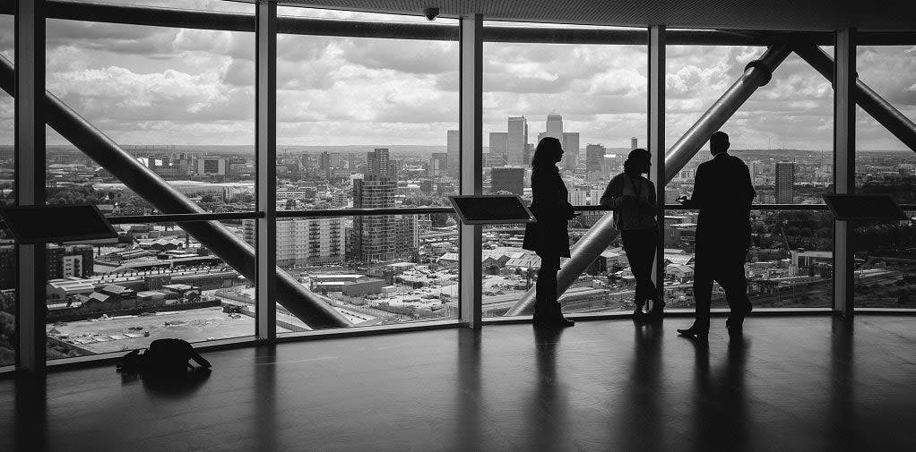 Black and white photo of three people in an office building
