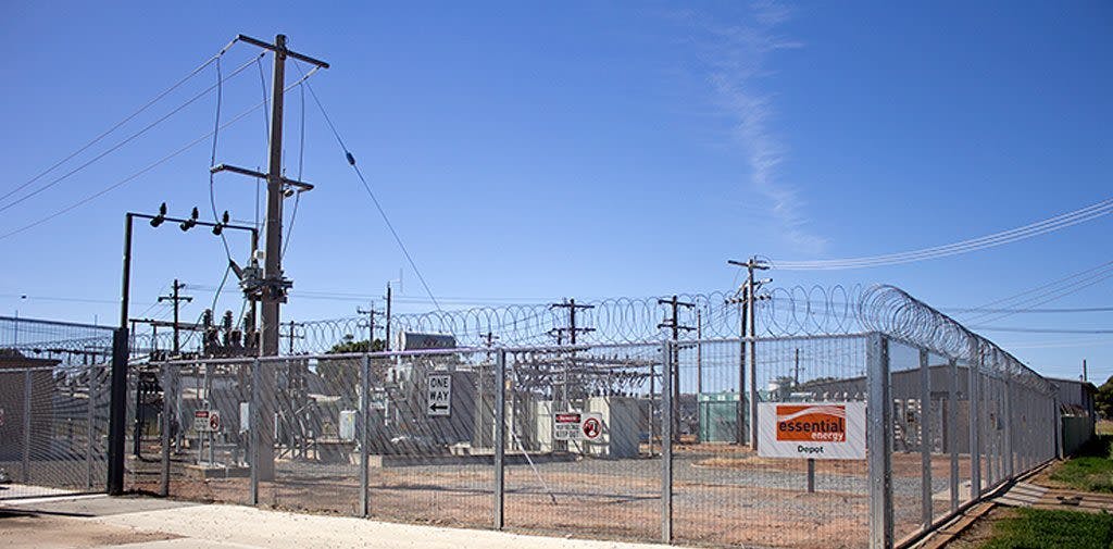 A power station surrounded by chain link fence 