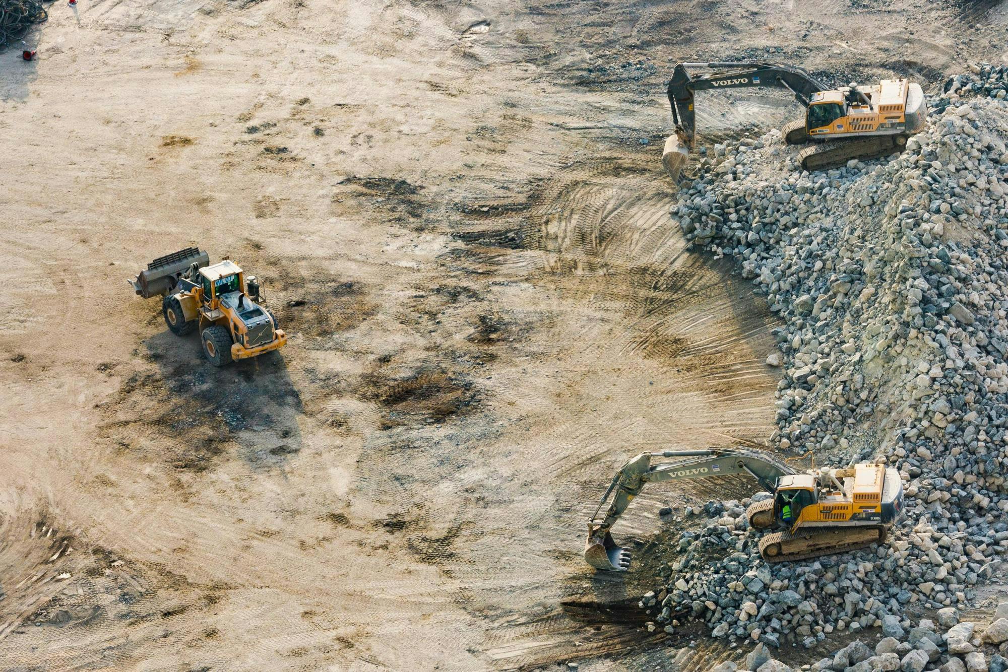 A construction site with three heavy machines working