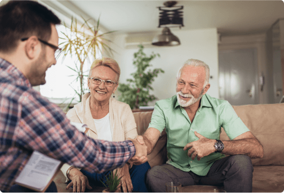 Elderly couple happily greeting advisor
